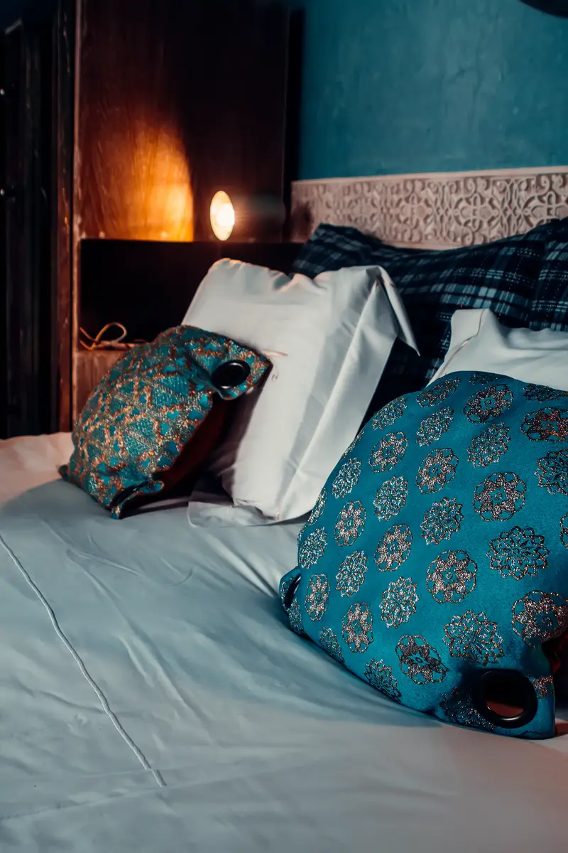 Coussins brodés bleu canard sur un lit