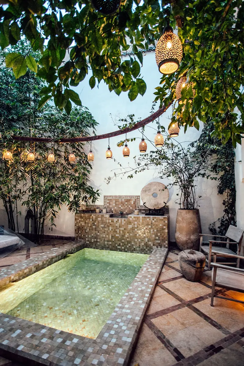 Bassin du patio le soir, sous une guirlande de lanternes
