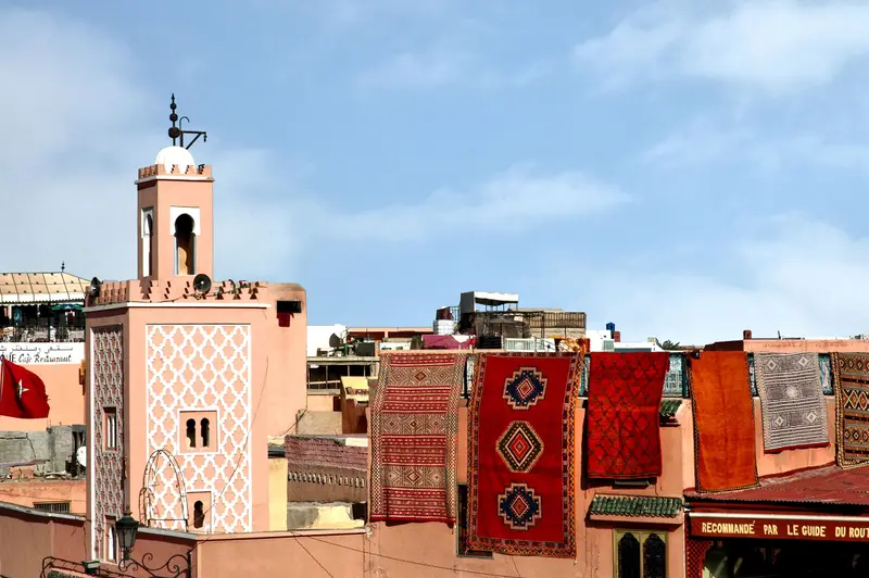 Tapis berbères étendus sur les toits de la médina, près d’un minaret