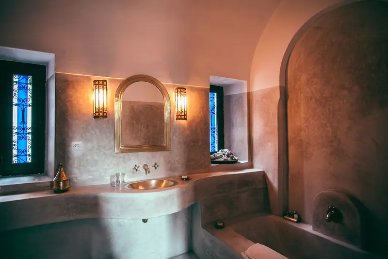 Salle de bain en tadelakt avec baignoire et vasque en pierre